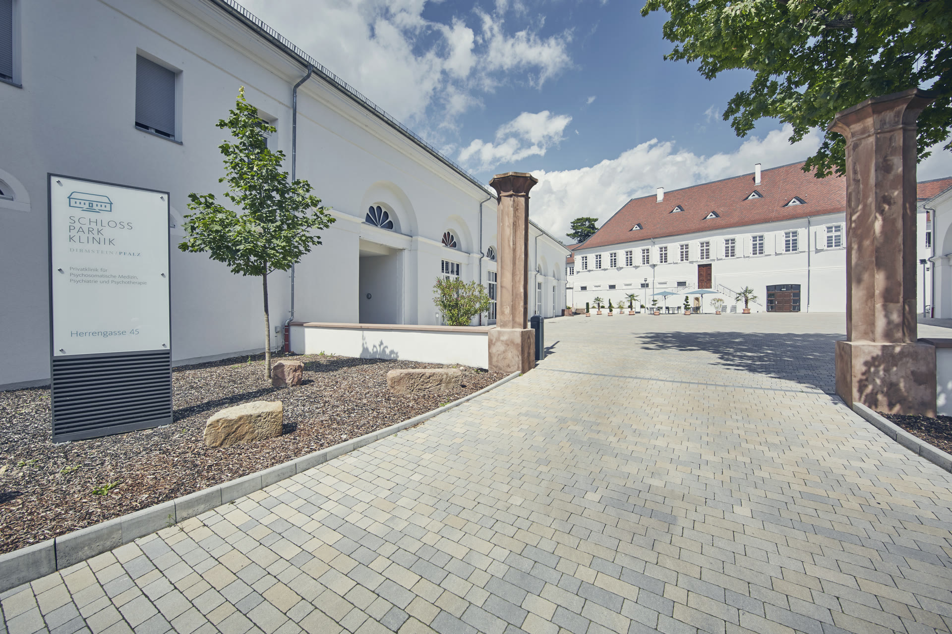 Saniertes Hofensemble der Schlossparkklinik mit hellem Pflaster und restaurierten Fassaden