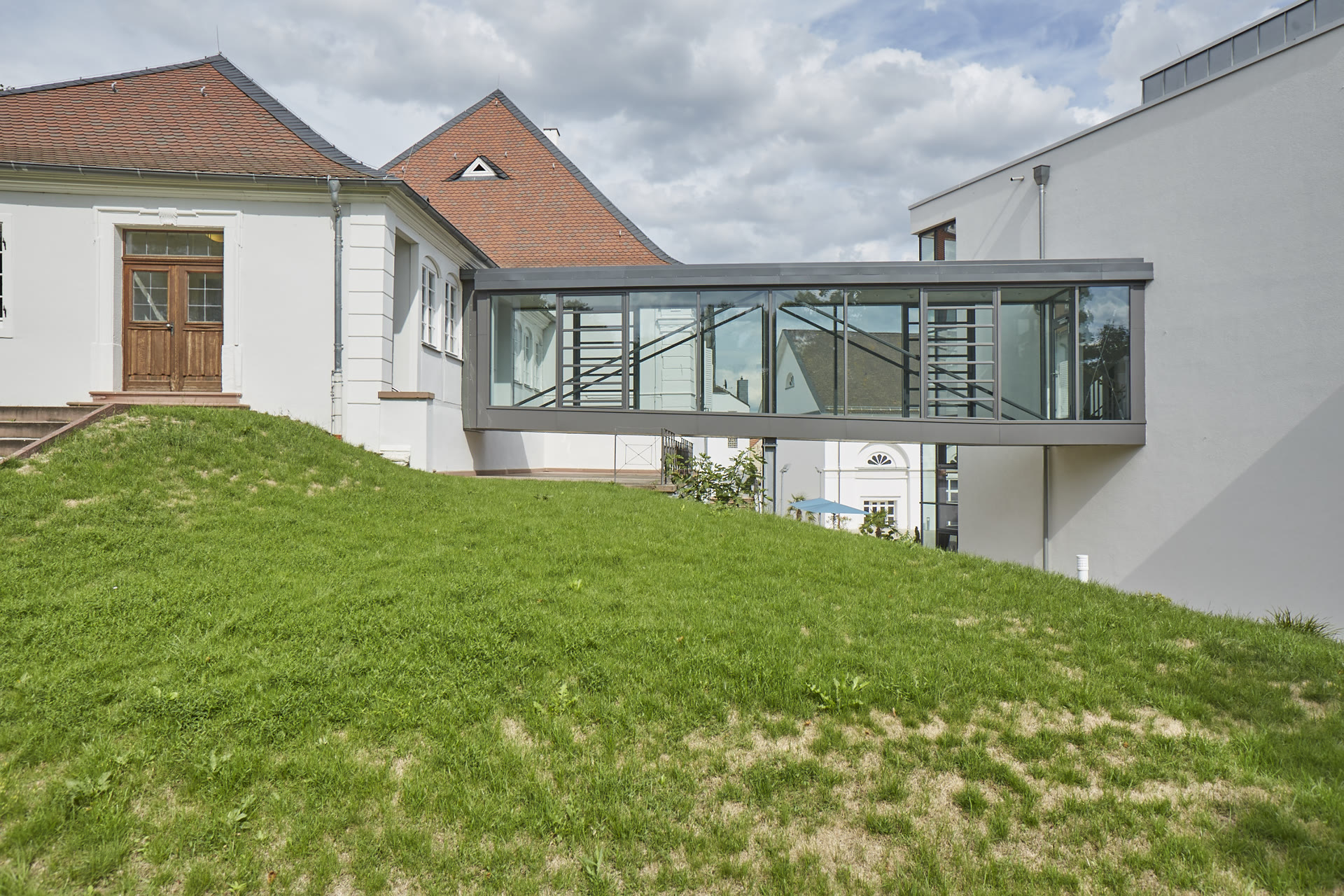 Verglaste Brücke zwischen dem historischen Gebäude und dem modernen Kliniktrakt