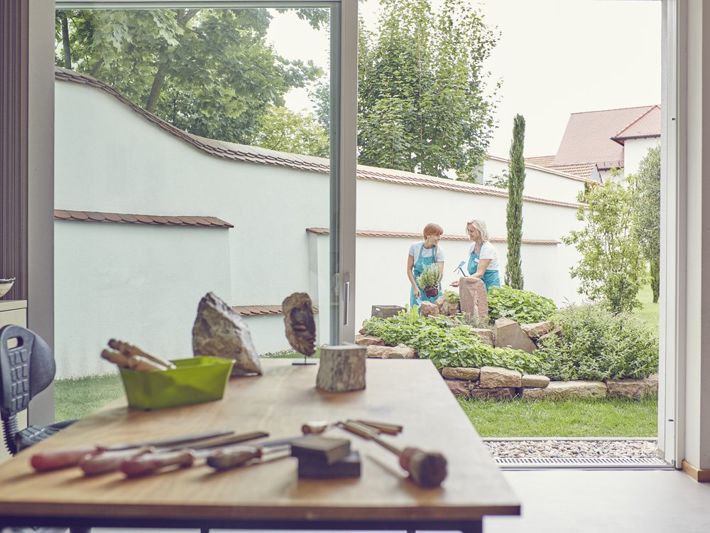 Werkbank mit Werkzeug im Kreativtherapieraum, dahinter der Kräutergarten